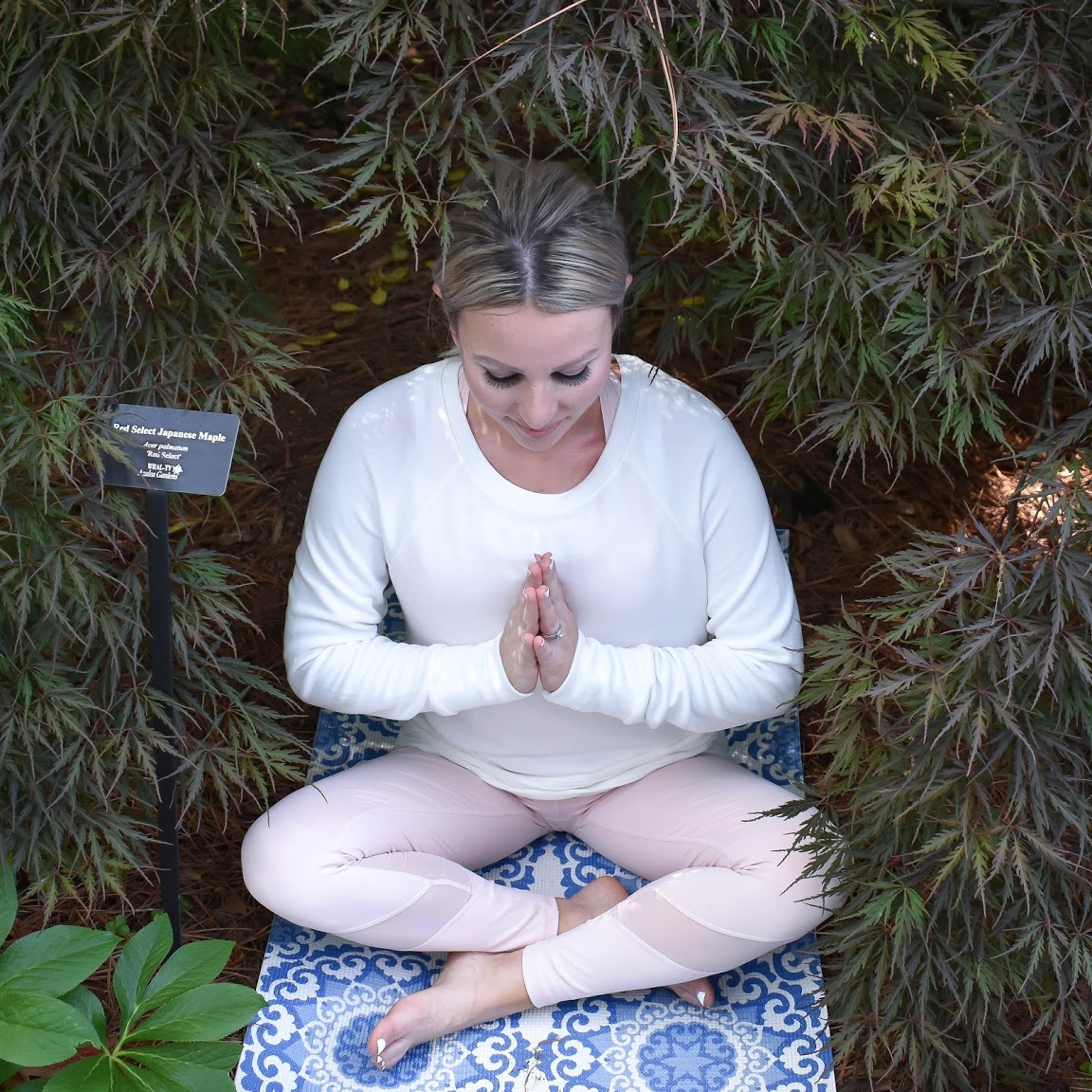 meditation photo, woman in calming garden on yoga mat