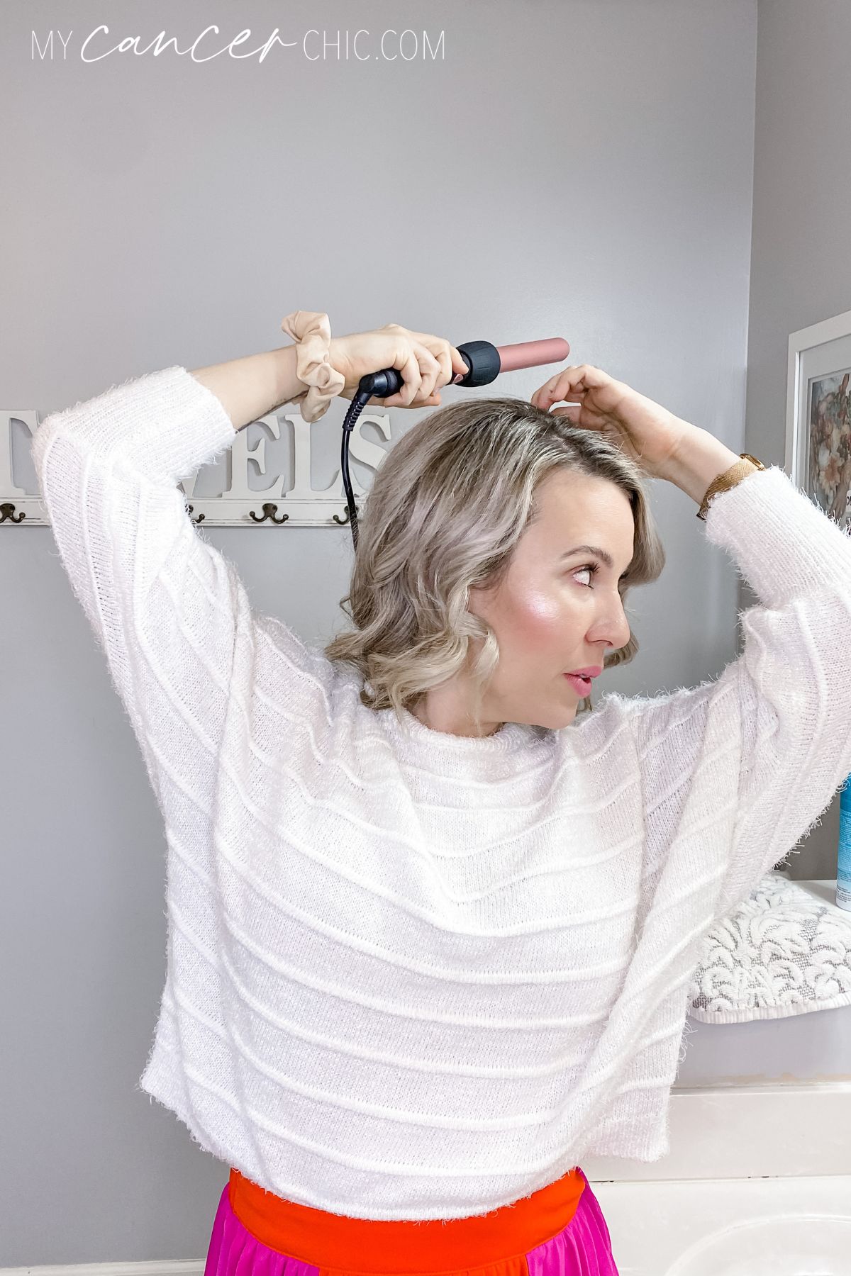 woman using a 1 inch curling wand on short hair