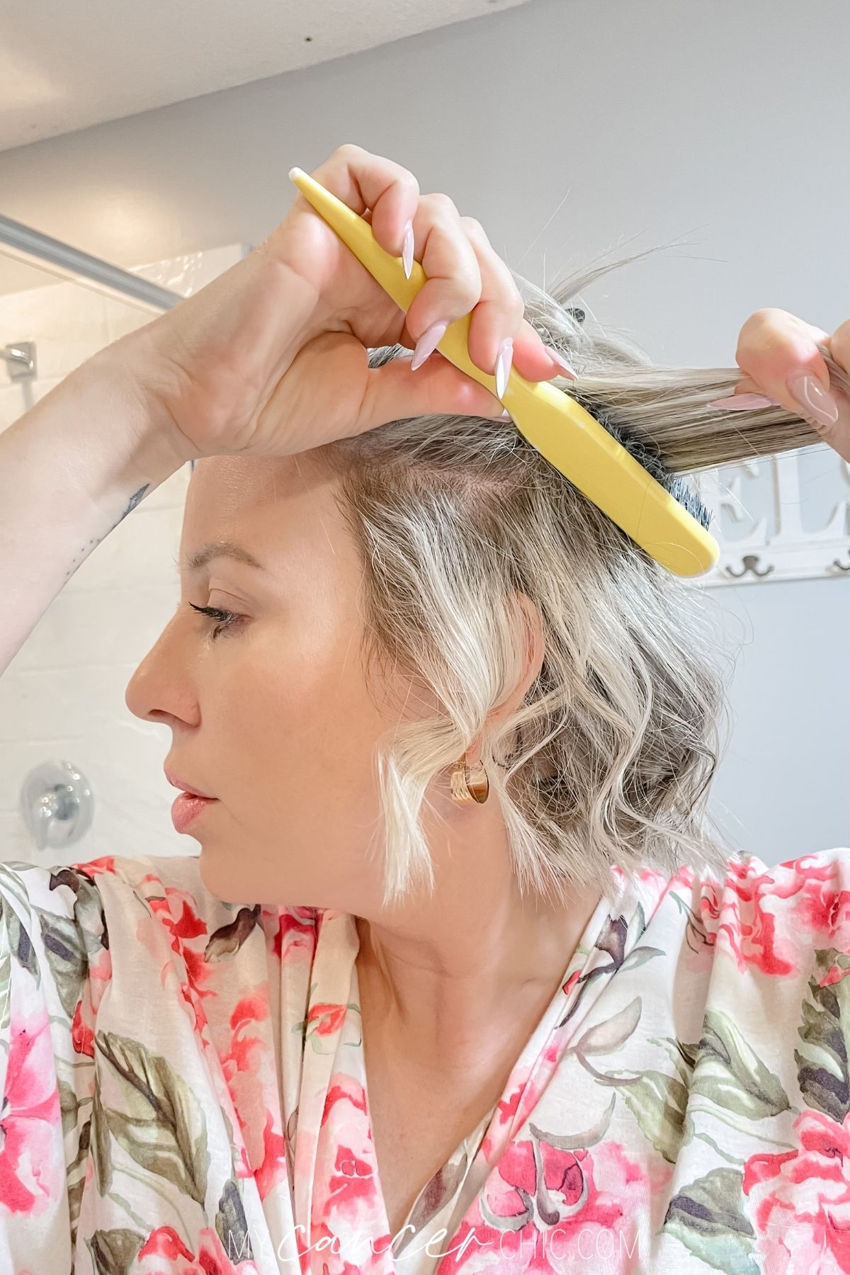 woman is using a teaser comb on short hair to add volume