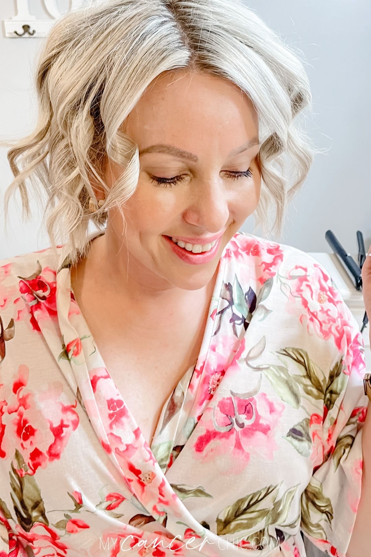 woman poses for picture with short curly hair