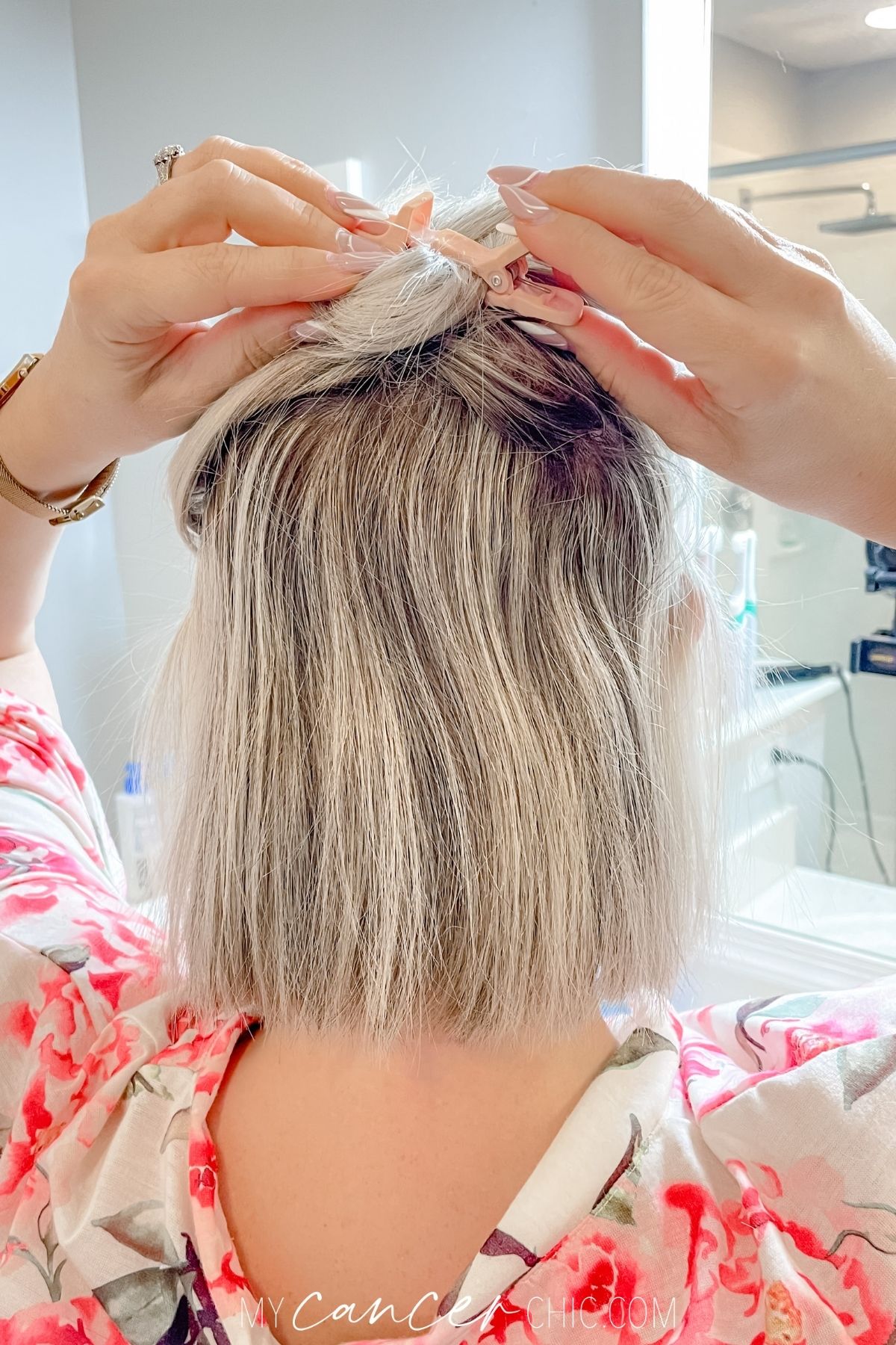 woman is applying hair clip to separate the top layer of hair from the bottom layer