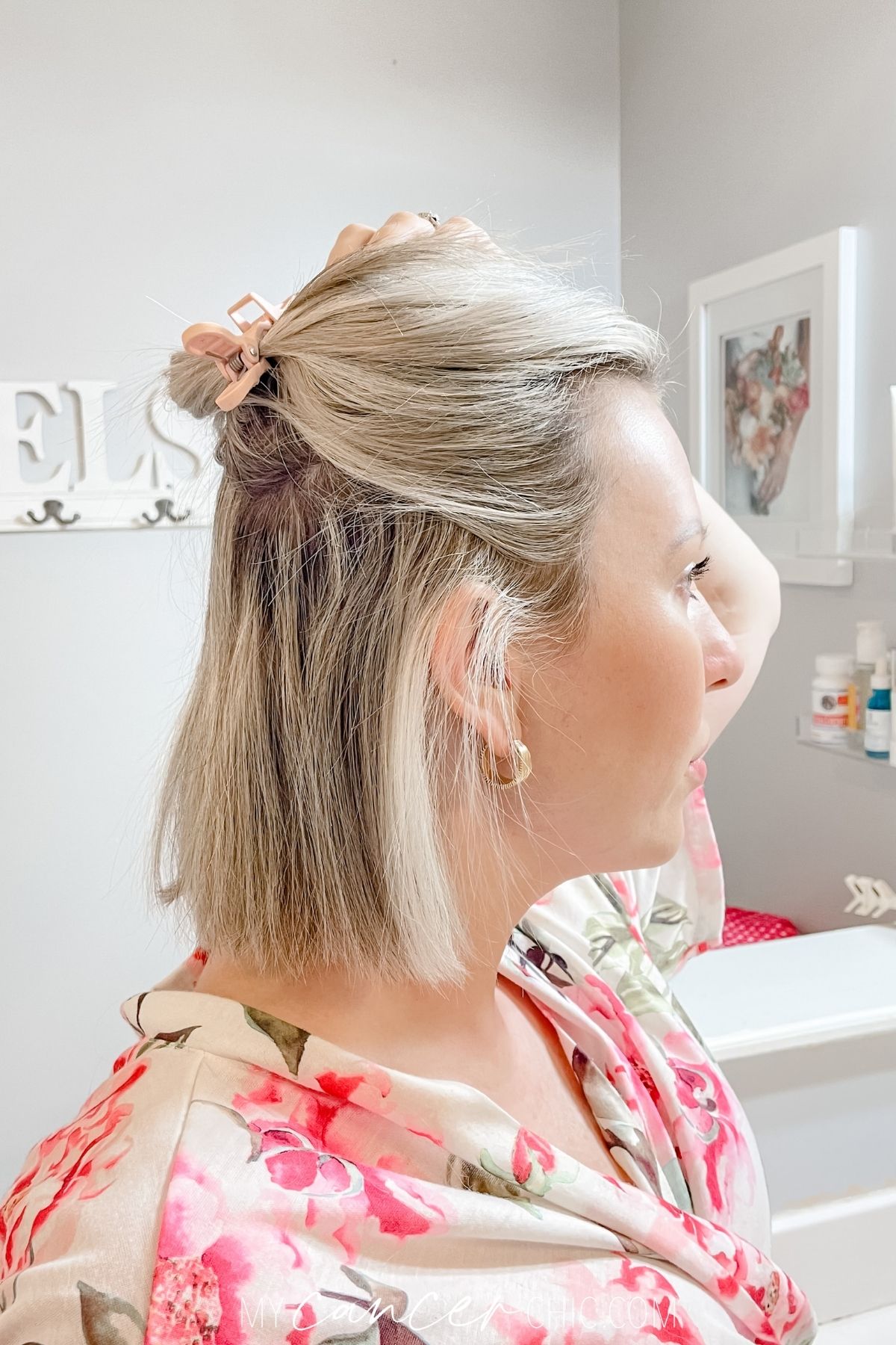 woman is applying hair clip to separate the top layer of hair from the bottom layer