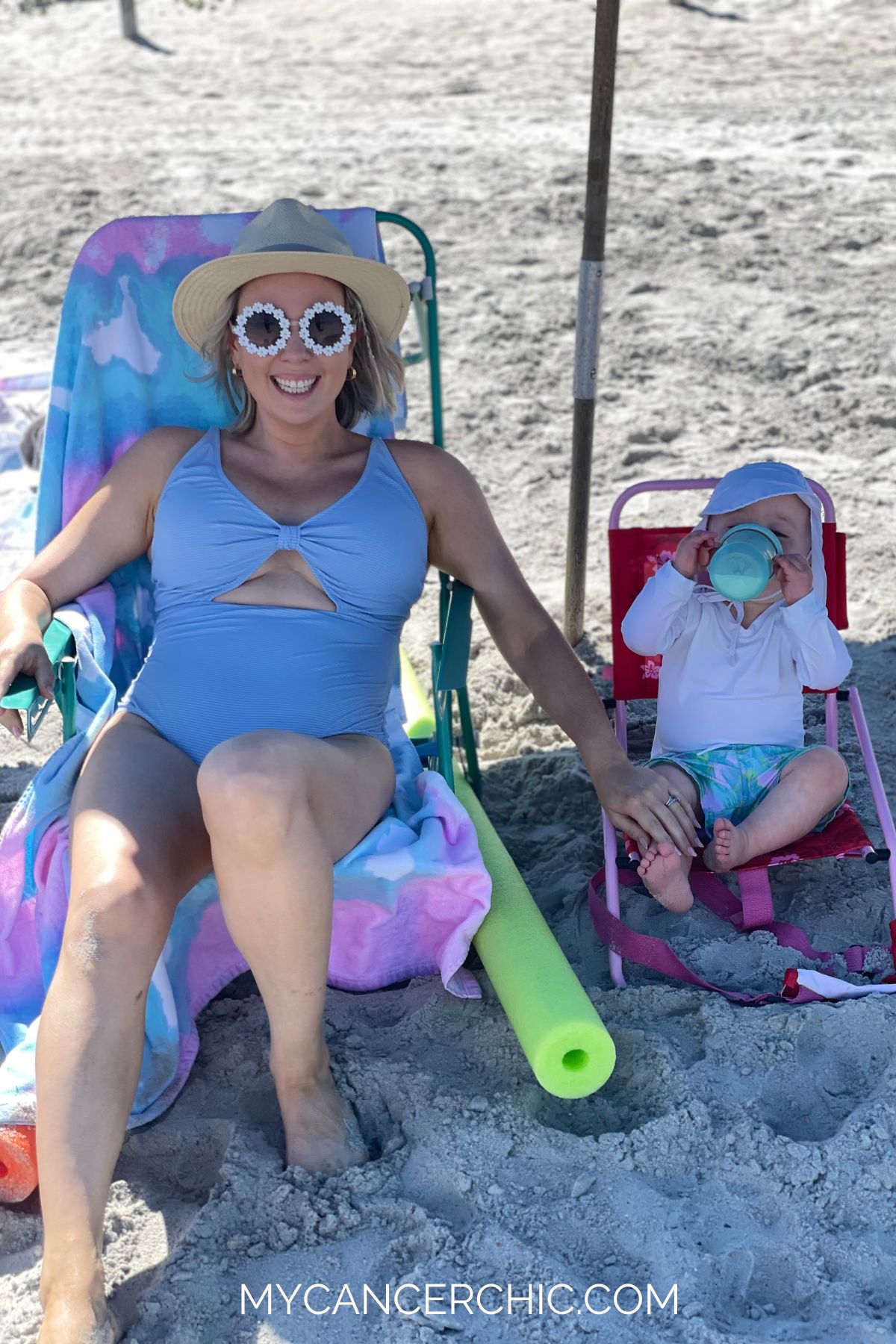 mother and toddler son sitting in beach chairs under the shade