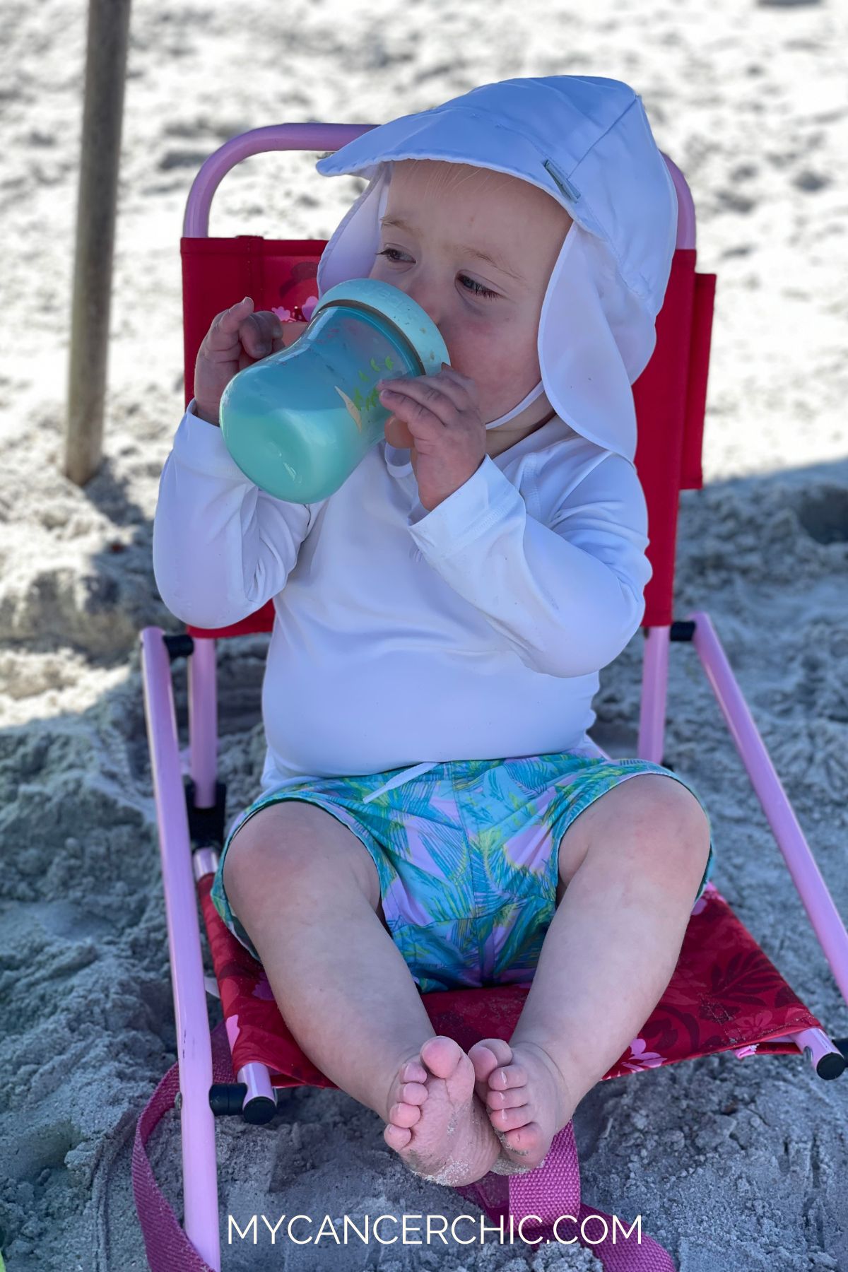 toddler sitting in beach chair on the beach